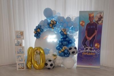 Table ronde avec verres vides, assiettes empilées, couverts, serviettes et desserts en arrière-plan.