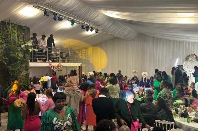 Table ronde avec verres vides, assiettes empilées, couverts, serviettes et desserts en arrière-plan.