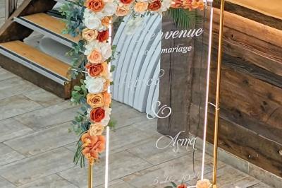 Table ronde avec verres vides, assiettes empilées, couverts, serviettes et desserts en arrière-plan.