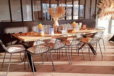 Comptoirs en bois avec décorations florales, installés en extérieur sous un ciel dégagé près de bâtiments modernes.