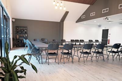 Comptoirs en bois avec décorations florales, installés en extérieur sous un ciel dégagé près de bâtiments modernes.