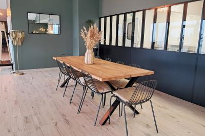 Comptoirs en bois avec décorations florales, installés en extérieur sous un ciel dégagé près de bâtiments modernes.