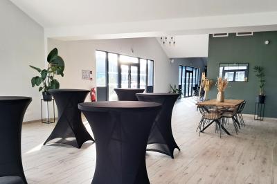 Comptoirs en bois avec décorations florales, installés en extérieur sous un ciel dégagé près de bâtiments modernes.