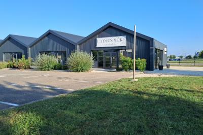 Comptoirs en bois avec décorations florales, installés en extérieur sous un ciel dégagé près de bâtiments modernes.