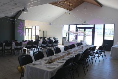 Comptoirs en bois avec décorations florales, installés en extérieur sous un ciel dégagé près de bâtiments modernes.