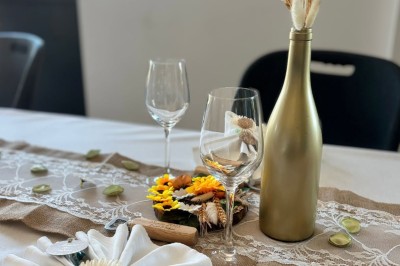 Comptoirs en bois avec décorations florales, installés en extérieur sous un ciel dégagé près de bâtiments modernes.