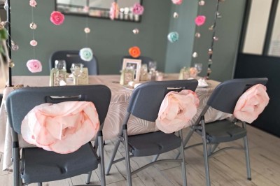 Comptoirs en bois avec décorations florales, installés en extérieur sous un ciel dégagé près de bâtiments modernes.