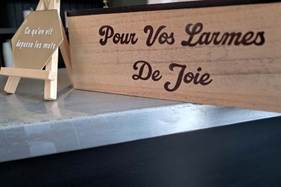 Comptoirs en bois avec décorations florales, installés en extérieur sous un ciel dégagé près de bâtiments modernes.