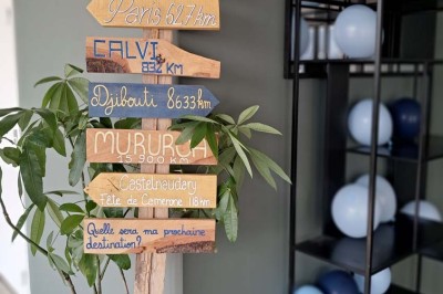 Comptoirs en bois avec décorations florales, installés en extérieur sous un ciel dégagé près de bâtiments modernes.