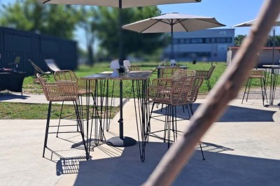Comptoirs en bois avec décorations florales, installés en extérieur sous un ciel dégagé près de bâtiments modernes.