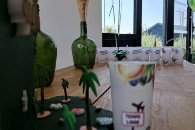 Comptoirs en bois avec décorations florales, installés en extérieur sous un ciel dégagé près de bâtiments modernes.