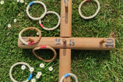 Disque en bois avec des cercles numérotés et des pions en bois disposés sur différentes zones de points.