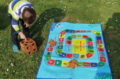 Disque en bois avec des cercles numérotés et des pions en bois disposés sur différentes zones de points.