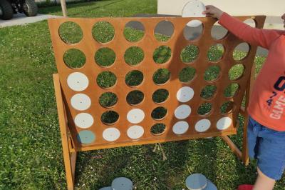 Disque en bois avec des cercles numérotés et des pions en bois disposés sur différentes zones de points.