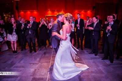 Des serveurs en tenue formelle apportent des plateaux avec des desserts ornés de cierges magiques dans une ambiance festive.