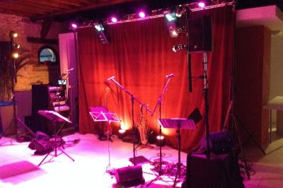 Salle de réception décorée avec des tables rondes, des chandeliers allumés et un éclairage tamisé aux tons chauds.