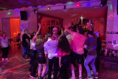 Salle de réception décorée avec des tables rondes, des chandeliers allumés et un éclairage tamisé aux tons chauds.
