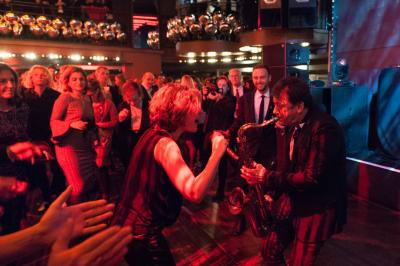 Salle de réception décorée avec des tables rondes, des chandeliers allumés et un éclairage tamisé aux tons chauds.