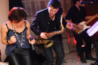 Salle de réception décorée avec des tables rondes, des chandeliers allumés et un éclairage tamisé aux tons chauds.