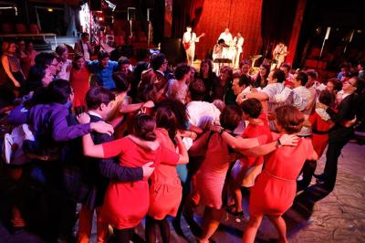 Salle de réception décorée avec des tables rondes, des chandeliers allumés et un éclairage tamisé aux tons chauds.