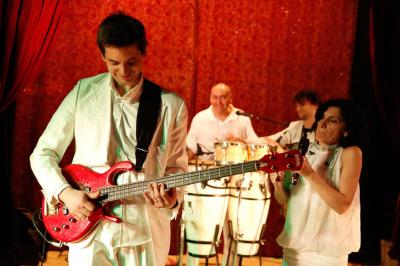 Salle de réception décorée avec des tables rondes, des chandeliers allumés et un éclairage tamisé aux tons chauds.