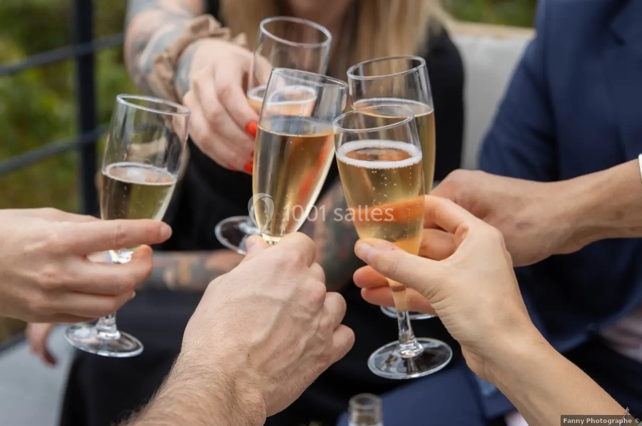 Location salle Saint-Genès-de-Lombaud (Gironde) - Domaine du Château Icla #16 Des mains trinquent avec des flûtes de champagne lors d'une célébration en extérieur.
