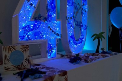 Décoration d'anniversaire avec bougies dorées et gobelets ornés de motifs festifs et du chiffre 60.