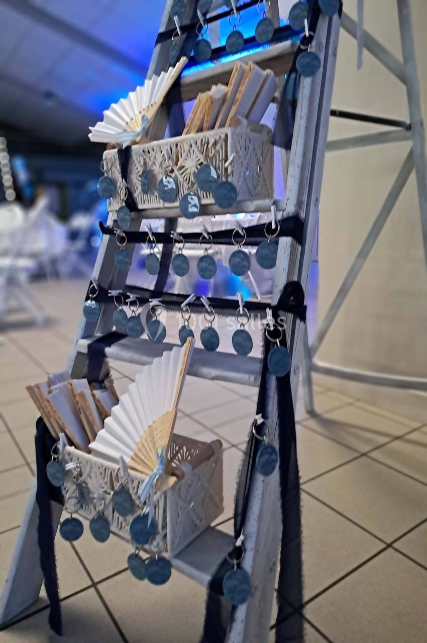 Échelle décorative avec des éventails et des médaillons suspendus, disposée dans un espace intérieur lumineux.