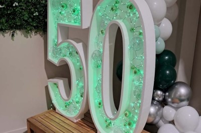 Décoration d'anniversaire avec bougies dorées et gobelets ornés de motifs festifs et du chiffre 60.