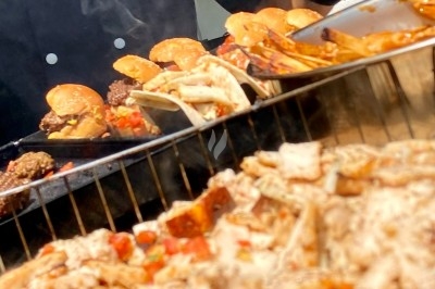 Camion-restaurant vintage servant des pâtes, gnocchis et cocktails, décoré de plantes et guirlandes lumineuses.