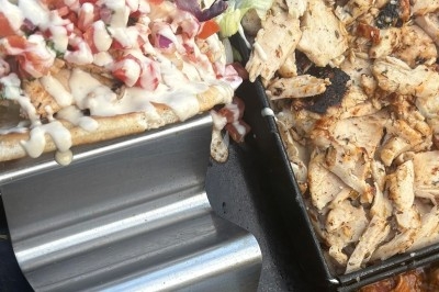 Camion-restaurant vintage servant des pâtes, gnocchis et cocktails, décoré de plantes et guirlandes lumineuses.