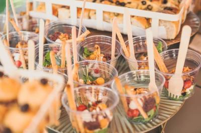 Plateau de fromages variés avec pain, raisins, confiture et couteau sur une planche en bois.