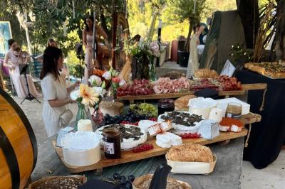 Plateau de fromages variés avec pain, raisins, confiture et couteau sur une planche en bois.