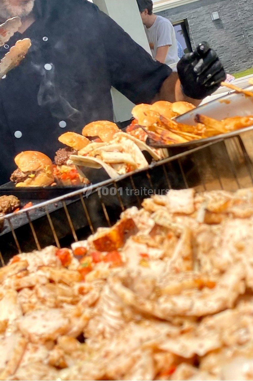 Chef préparant des viandes grillées et des burgers sur un barbecue, avec des aliments en gros plan au premier plan.