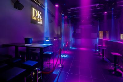 Personnes dansant avec des casques audio dans une ambiance de lumière bleue et rose lors d'une soirée silencieuse.