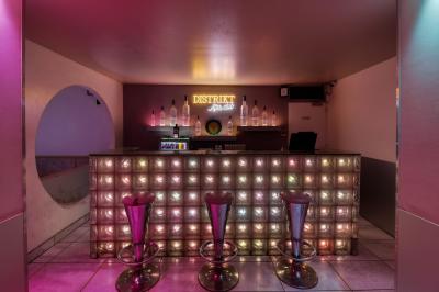 Personnes dansant avec des casques audio dans une ambiance de lumière bleue et rose lors d'une soirée silencieuse.