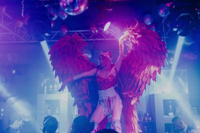 Personnes dansant avec des casques audio dans une ambiance de lumière bleue et rose lors d'une soirée silencieuse.