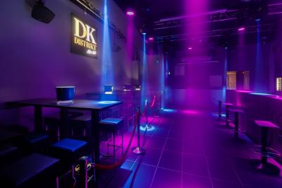 Personnes dans une discothèque sombre participant à une soirée silencieuse avec des casques audio lumineux.