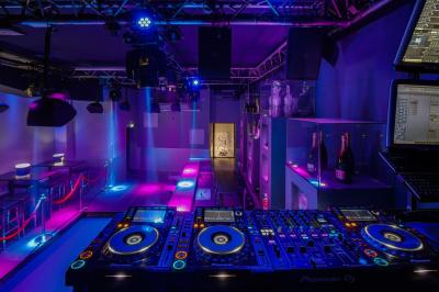 Personnes dans une discothèque sombre participant à une soirée silencieuse avec des casques audio lumineux.