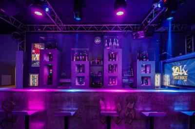 Personnes dans une discothèque sombre participant à une soirée silencieuse avec des casques audio lumineux.