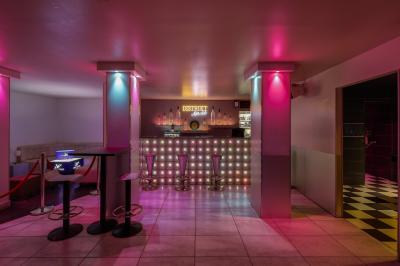 Personnes dans une discothèque sombre participant à une soirée silencieuse avec des casques audio lumineux.