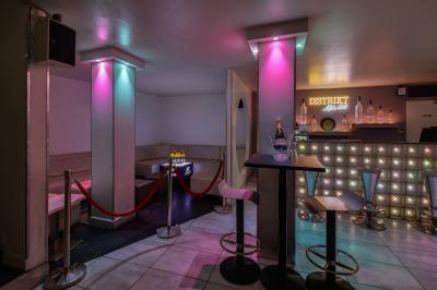 Personnes dans une discothèque sombre participant à une soirée silencieuse avec des casques audio lumineux.