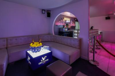 Personnes dans une discothèque sombre participant à une soirée silencieuse avec des casques audio lumineux.