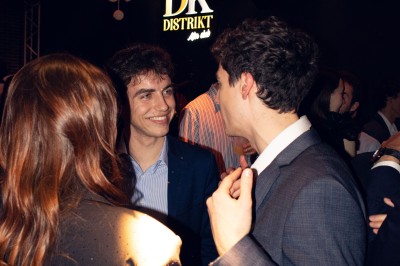 Salle de bain moderne avec murs gris, carrelage au sol clair, et lavabos intégrés dans un meuble noir carrelé.