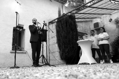Un couple danse sur une piste extérieure éclairée, entouré de bulles, avec un DJ en arrière-plan.