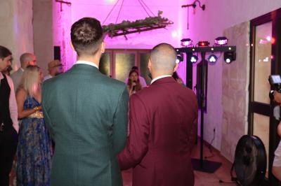 Un couple danse sur une piste extérieure éclairée, entouré de bulles, avec un DJ en arrière-plan.