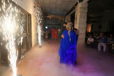 Un couple danse sur une piste extérieure éclairée, entouré de bulles, avec un DJ en arrière-plan.