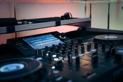 Un couple danse sur une piste extérieure éclairée, entouré de bulles, avec un DJ en arrière-plan.