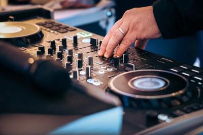 Un couple danse sur une piste extérieure éclairée, entouré de bulles, avec un DJ en arrière-plan.