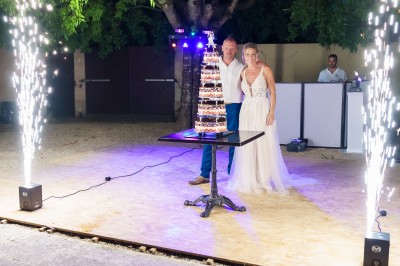 Un couple danse sur une piste extérieure éclairée, entouré de bulles, avec un DJ en arrière-plan.